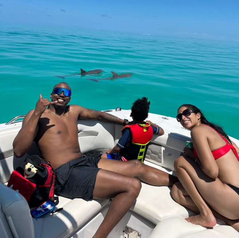 Smiling family gliding on Dolphin Safari Charters boat among wild dolphins