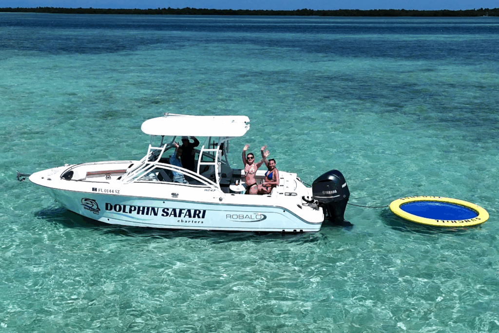 Private charter boat at sandbar near Key West with guests enjoying dolphin watching tour